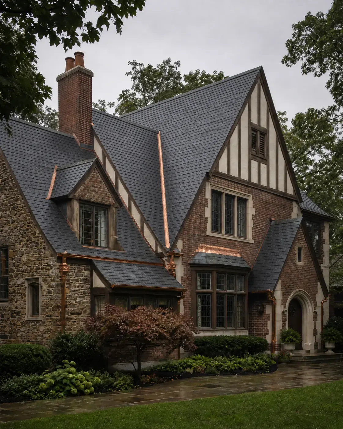 Historic Tudor-style home with steep slate roof planes and copper details