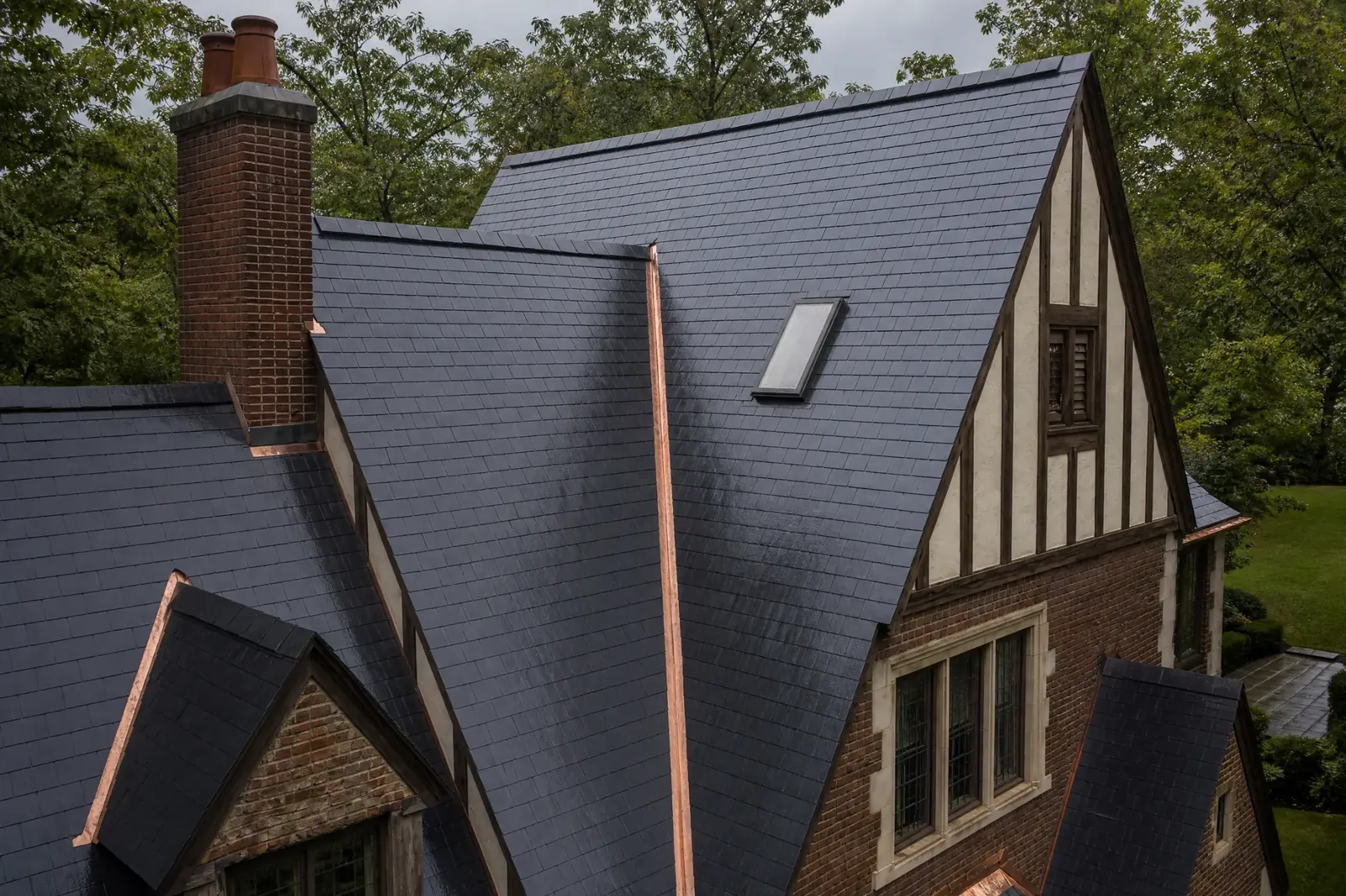 Slate roof planes with an integrated skylight and copper valley detail